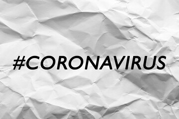 Hashtag Coronavirus written on white crumpled paper