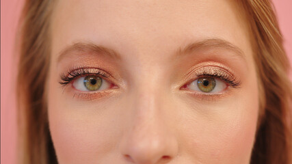 Fototapeta premium Big green eyes of young caucasian smiling woman, close up, studio shot. High quality photo