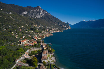 Fototapeta na wymiar Panoramic view of the Villa in the town of Gargnano on Lake Garda Italy. High-altitude aerial view of the architecture on Lake Garda. Villa on Lake Garda in the background Alps and blue sky.