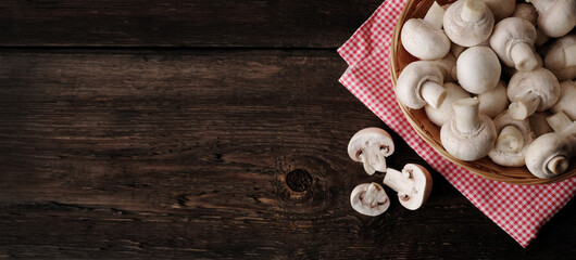 Fresh champignon mushrooms on wooden table, closeup. Space for text