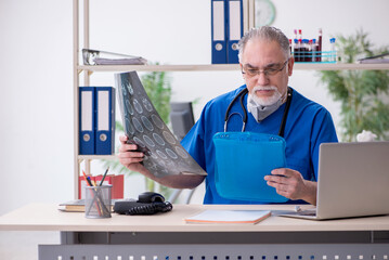 Old male doctor working in the clinic