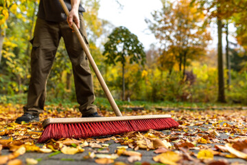 Im Herbst Blätter zu Hause zusammenfegen