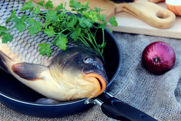 Fresh carp in a frying pan, close-up, bokeh-the concept of cooking delicious fish dishes