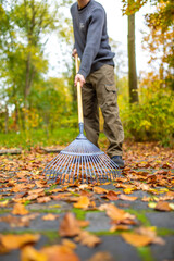 Den Hof im Herbst von Blättern befreihen zusammen fegen