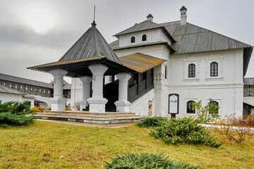 Fototapeta na wymiar a two-story white monastery building with a wooden roof