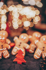 Many Christmas cookies in the form of gingerbread men depicting people celebrating the New Year in the forest near the Christmas tree