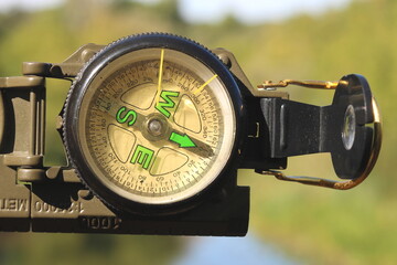 Classic navigation compass on natural background as symbol of tourism with compass, travel with compass and outdoor activities with compass © yarbeer