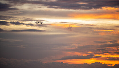 Fototapeta na wymiar Plane Flying into the sunset 