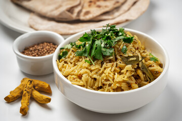 Kichari in a white plate on a light table near the condiments