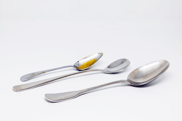 three different silver spoons on white background. Horizontal
