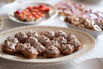 Bite sized finger food with mushroom salad filling in shortcrust pastry. Buffet style catering table setting.