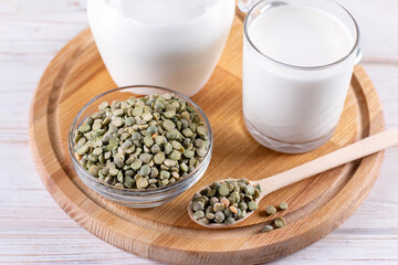 Green peas plant-based milk on a white table. Gluten-free, soy free, lactose-free product