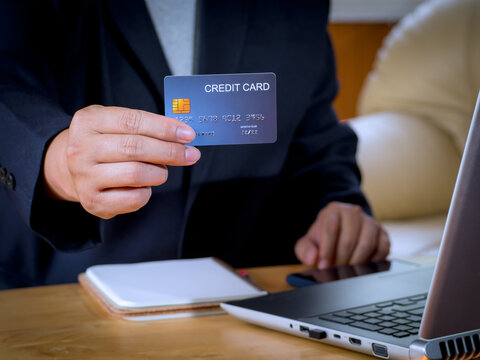 Businessman holding or showing blue creadit card for shopping online. E-commerce, commercial, payment concept.