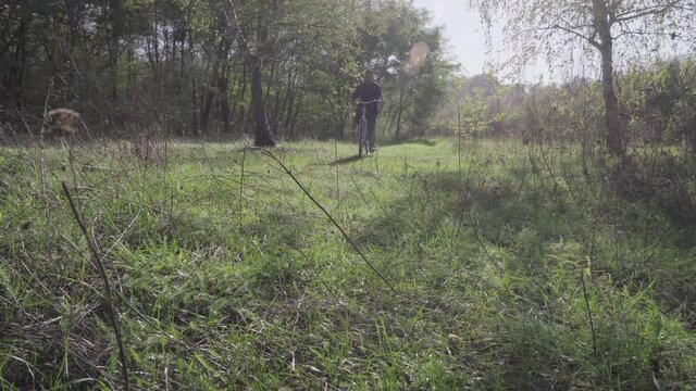 Man takes a walk in the autumn woods on a bicycle