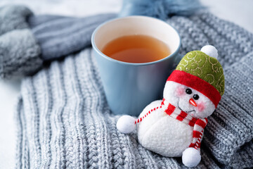 Winter Christmas holidays background with Cup of tea and wool hat, mittens and scarf