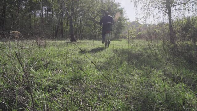 Man takes a walk in the autumn woods on a bicycle