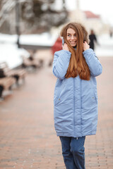 Fototapeta premium young woman are walking in the winter park. Winter park in the snow. Clothing advertising photo concept