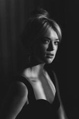 Close up studio portrait of a pretty blonde woman in black top.