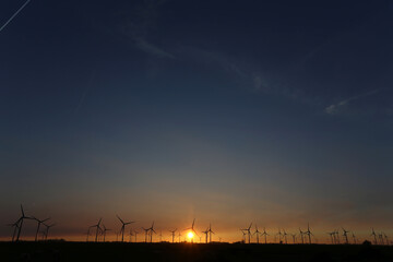 Fototapeta premium Windenergie und ein Farben froher Sonnenuntergang