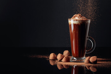 Truffles and glass of hot chocolate with whipped cream.