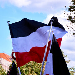 Flag of the former German Empire in the colors black white red blows in the wind