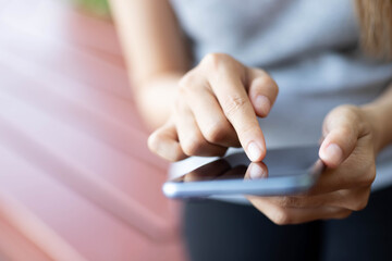 Women are typing messages choose products online,in the park.