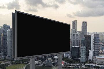 Fototapeta premium Blank black road billboard with Singapore cityscape background at sunset. Street advertising poster, mock up, 3D rendering. Side view. The concept of marketing communication to sell idea.