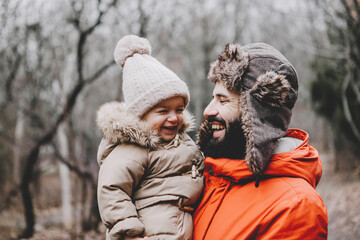 Handsome young dad and his little sweet daughter have fun outdoors in winter. Happy family spending time together. Family concept.