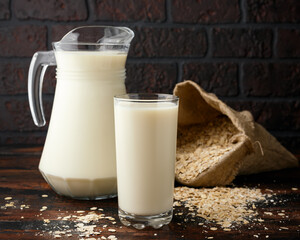 Vegan Oat milk in glass on rustic wooden table