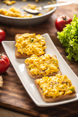 Scrambled eggs on toasts served on a plate