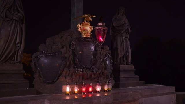 Walking Past Statue Of The Holy Crucifix And Calvary On Charles Bridge night. Follow Shot