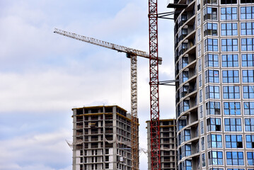 Tower cranes in action at construction site. Construction of skeleton of new modern residential buildings. Preparing to pour of concrete into formwork. Erection multi-storey residential building