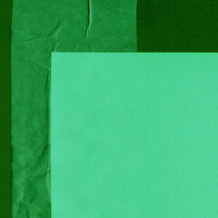 Green torn paper collage close-up. Texture made from various paper and cardboard parts. Damaged old paper background. Vintage blank wallpaper. Material design backdrop.