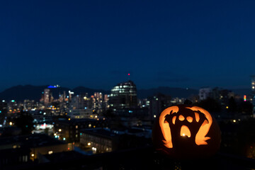 Ghost carved pumpkin with a city view background