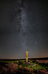 Milky way and foreground cross at North York Moors in portrait, Rosedale, UK.