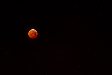 Blood moon (eclipse) with stars.