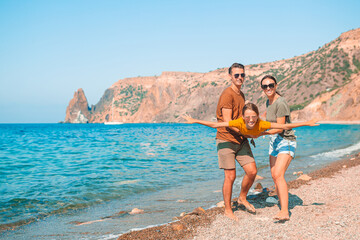 Fototapeta premium Young family on white beach during summer vacation