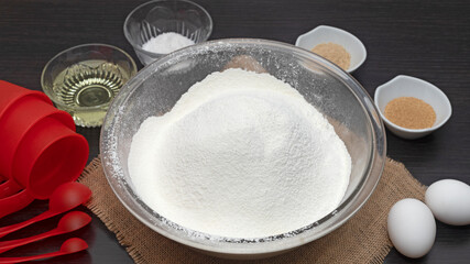 tazón de harina y otros ingredientes para preparar masa para hornear, huevos, levadura, sal,...