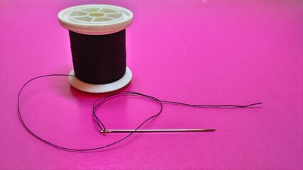 black thread reel and needle