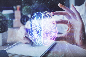 Multi exposure of writing hand on background with brain hologram. Concept of learning.