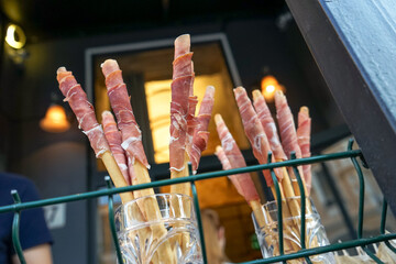 snacks with bacon and grissini on the terrace against the background of the restaurant in bokeh
