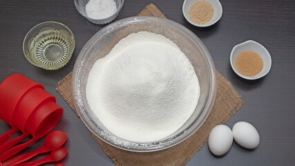 tazón de harina y otros ingredientes para preparar masa para hornear, huevos, levadura, sal,...