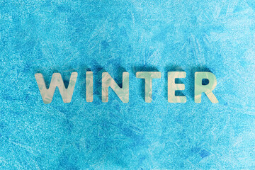 Winter greeting card, frame, banner. Winter text on shiny blue ice background. Winter concept