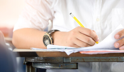 high school,university student study.hands holding pencil writing paper answer sheet.sitting lecture chair taking final exam attending in examination classroom.concept scholarship for education abroad