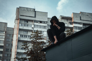 
the man in black is sitting on the roof