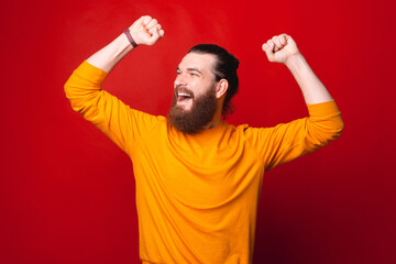 Fototapeta premium A bearded man is being excited looking away with both hands up .