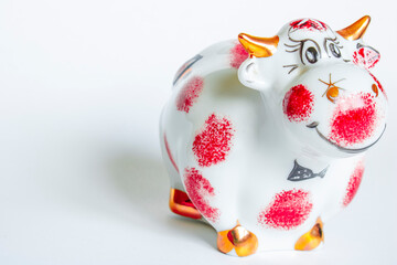 Red and white porcelain bull figurine on a white background. New year of the bull
