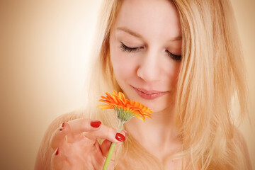 blonde Frau hält Blume