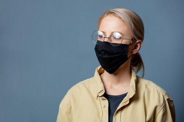 Woman in black face mask on grey background