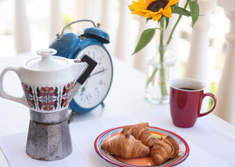Breakfast on the table with an old coffee maker. Baked products and cup of coffee. Outdoor coffee time on the terrace. Beautiful yellow sunflowers